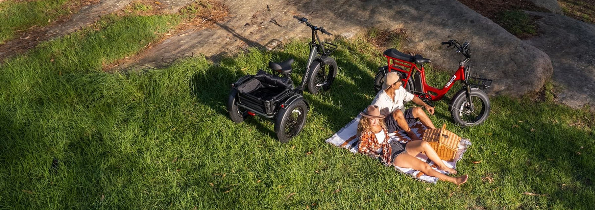 A couple having a picnic next to two Vamos Bikes electric rides.