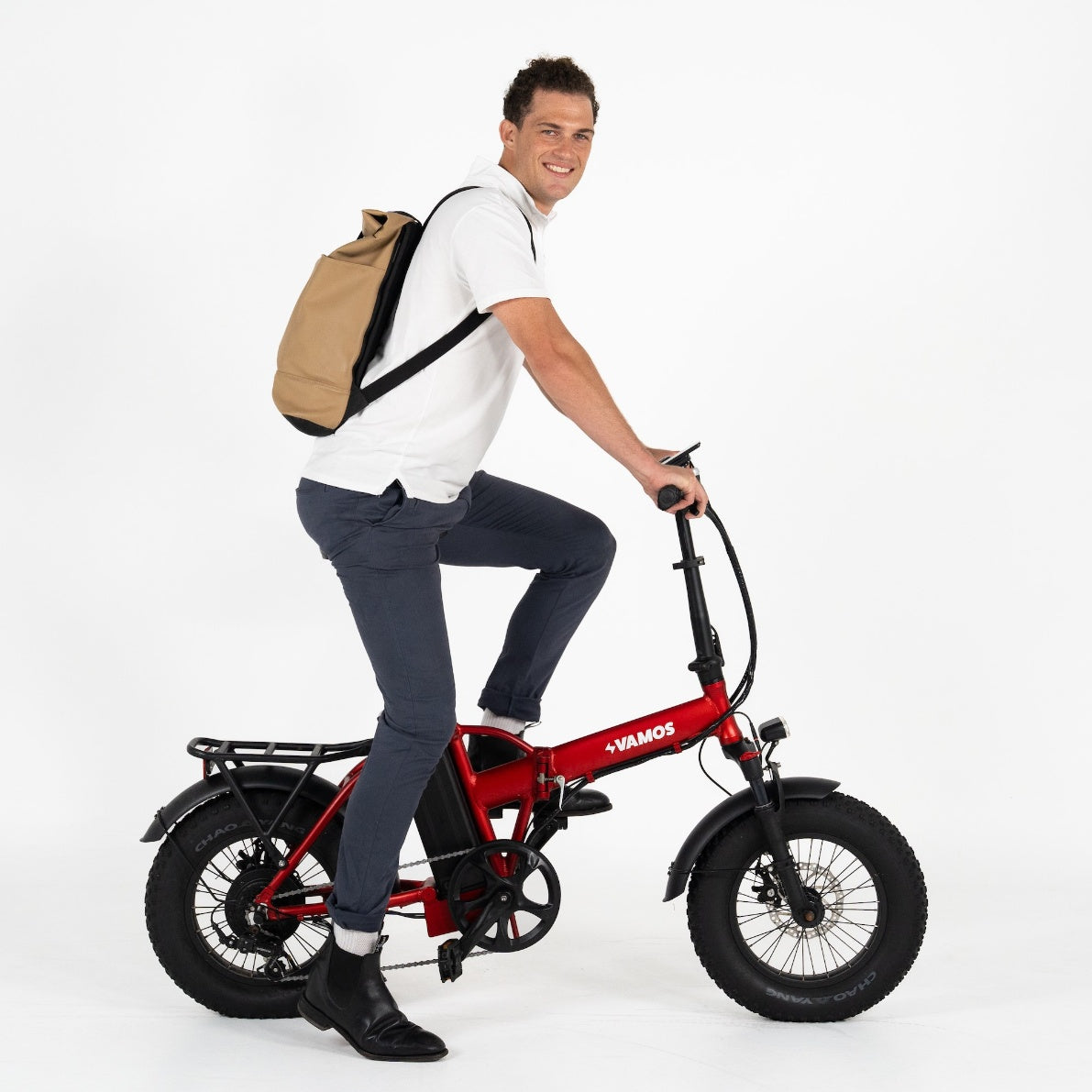 A person riding a red Vamos El Doblez folding electric fat-bike.