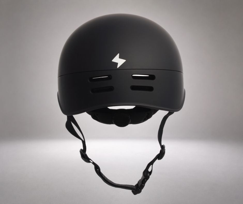 A protective multi-sport helmet, resembling a matte black skate-style or commuter helmet