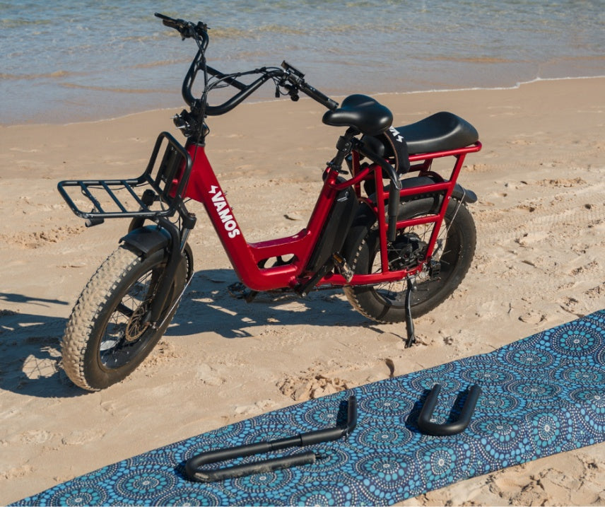 A red Vamos El Amigo compact cargo e-bike paired with an optional Two Pieces Surfboard Rack.