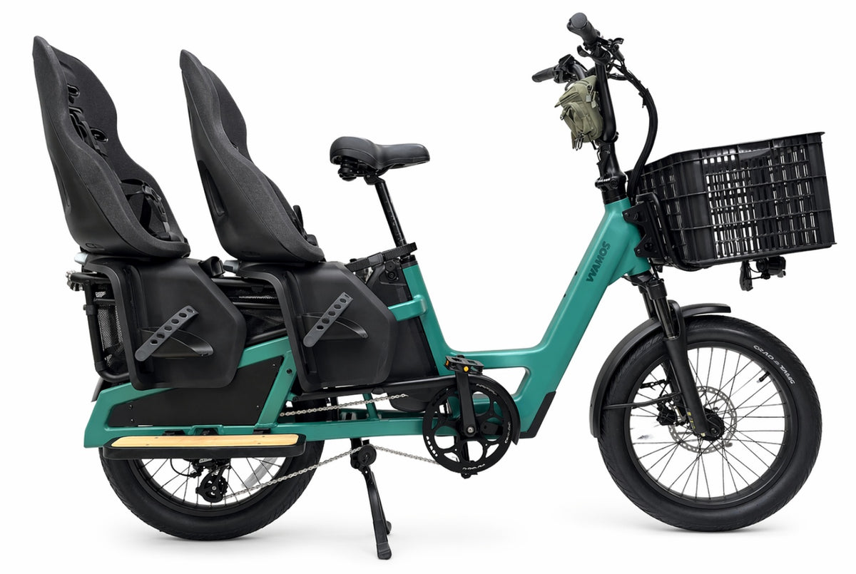 Vamos Amigo Plus 2026 - All-Purpose Passenger Commuter E-Bike, a teal-green family electric cargo bike equipped with dual rear child seats and a front storage basket.