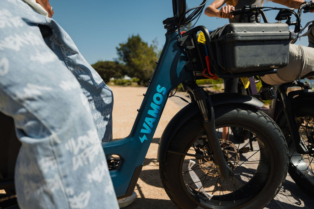 A blue Vamos Amigo Plus 2026 All-Purpose Passenger Commuter E-Bike Featuring fat tires and a front storage setup.