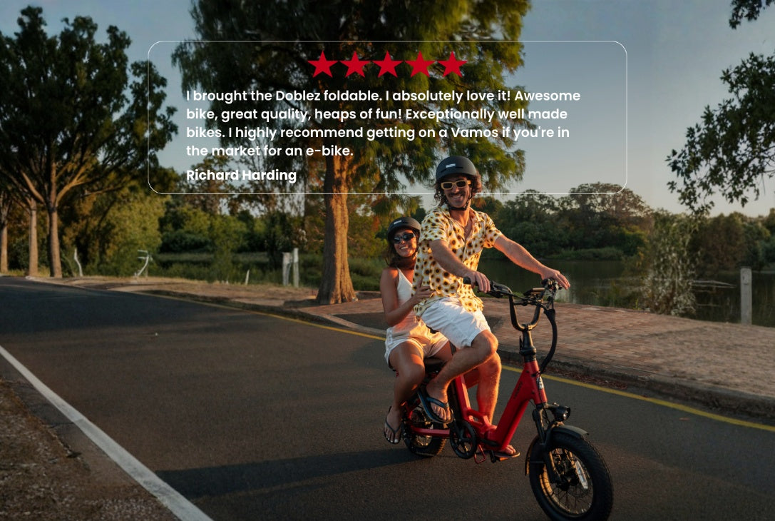 Vamos Doblez 2026 Foldable E-Bike carrying two riders on a paved path, overlaid with a five-star customer review