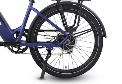The rear wheel assembly, chainstay-mounted kickstand, and integrated rear rack of a blue Vamos Rapido 2026 Daily Commuter E-Bike