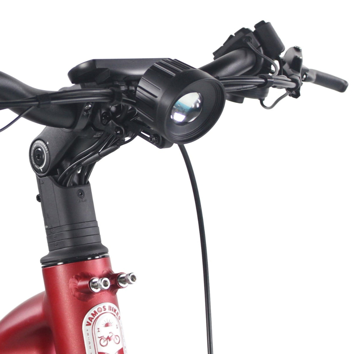 The handlebars, adjustable stem, and front LED headlight of a Vamos Bikes electric bicycle