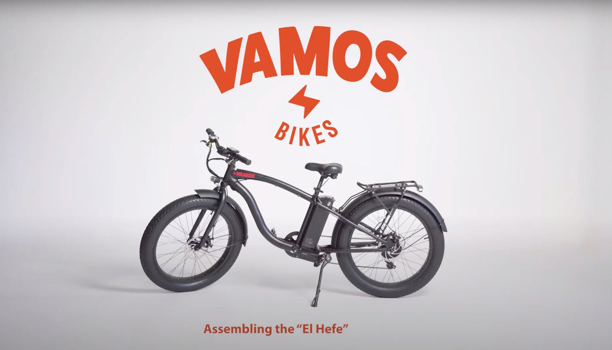 Fat-tyre electric cruiser bike displayed in a studio with Vamos Bikes branding