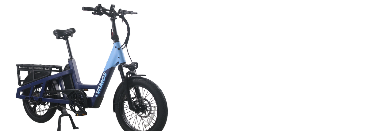 Step-through electric cargo bike with front rack and fat tyres on a white background