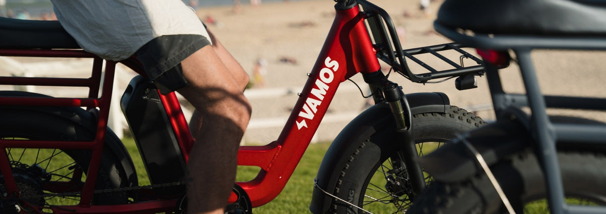 Red Vamos El Amigo compact cargo e-bike with fat tires and a front carry rack.