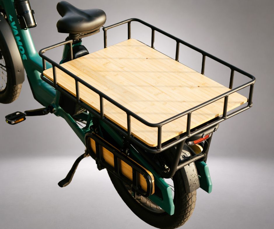 A rear cargo rack with a wooden platform on a green Vamos Amigo Plus electric commuter bike