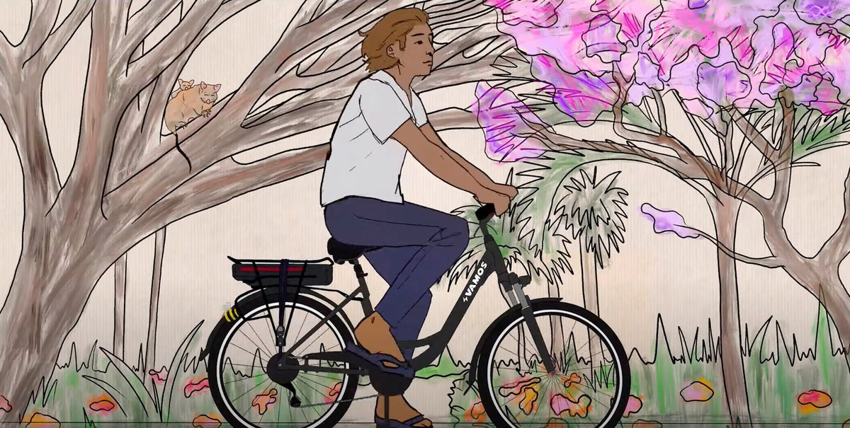 An illustration of a person with brown hair riding a black Vamos electric bicycle along a path lined with pink flowering trees and wildlife.