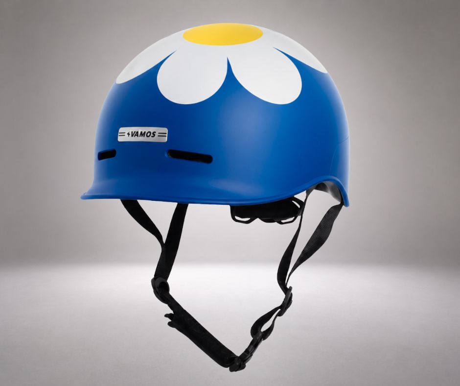 A blue Vamos bicycle helmet decorated with a large white and yellow daisy graphic 