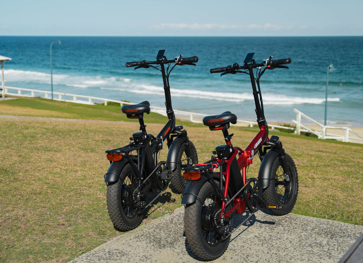 The Vamos El Doblez folding electric bike on a coastal beach path, showcasing its portability for Australian weekend trips.