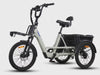 Grey Vamos electric tricycle with a front rack and rear cargo compartment set against a plain background.
